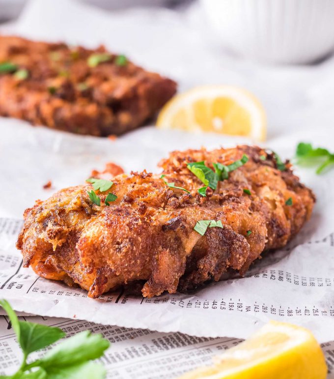 piece of beer battered fish on newspaper