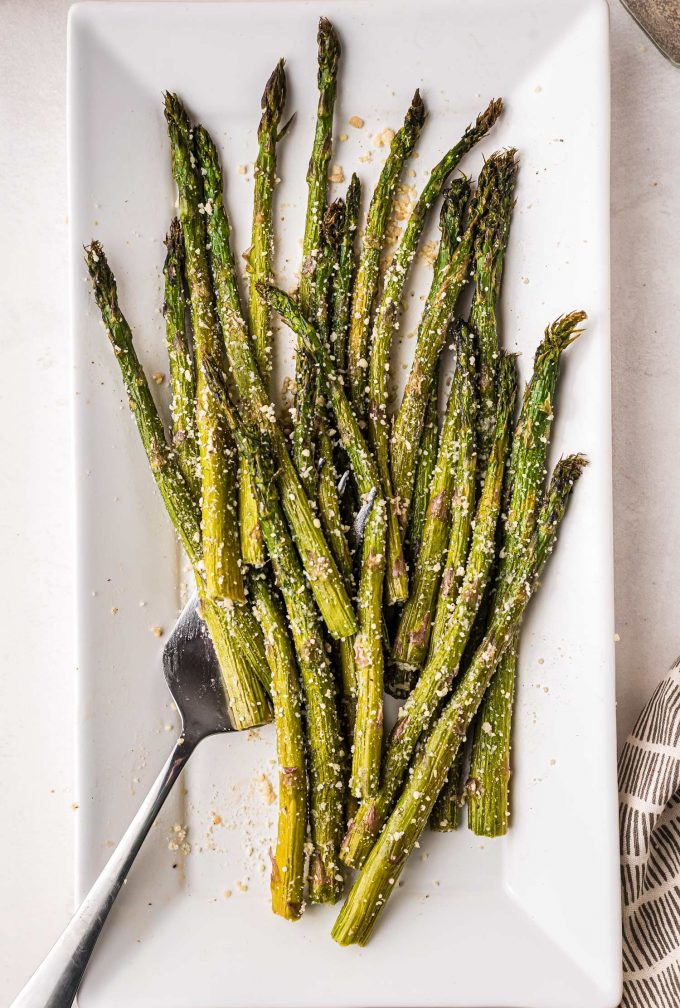 Here's a step-by-step guide for how to roast asparagus in the oven! This easy roasted asparagus recipe is ready in under 30 minutes, and uses simple, easy to find ingredients. It's just the best way to cook asparagus! #asparagus #roasted #vegetable #oven #baked