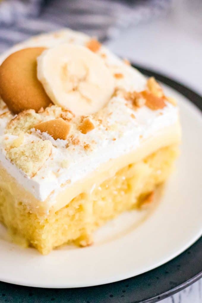 This Banana Pudding Poke Cake is the easiest and most delicious banana dessert around! Buttery yellow cake is infused with banana pudding, then slathered with whipped cream, crushed vanilla wafers and banana slices! Naturally a make ahead dessert, this is a dessert recipe the whole family will love! #pokecake #yellowcake #bananapudding #dessert #baking