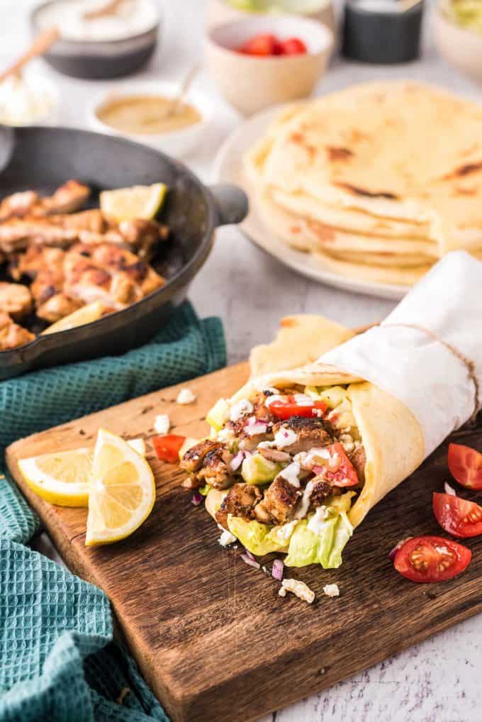 table spread with chicken shawarma wraps