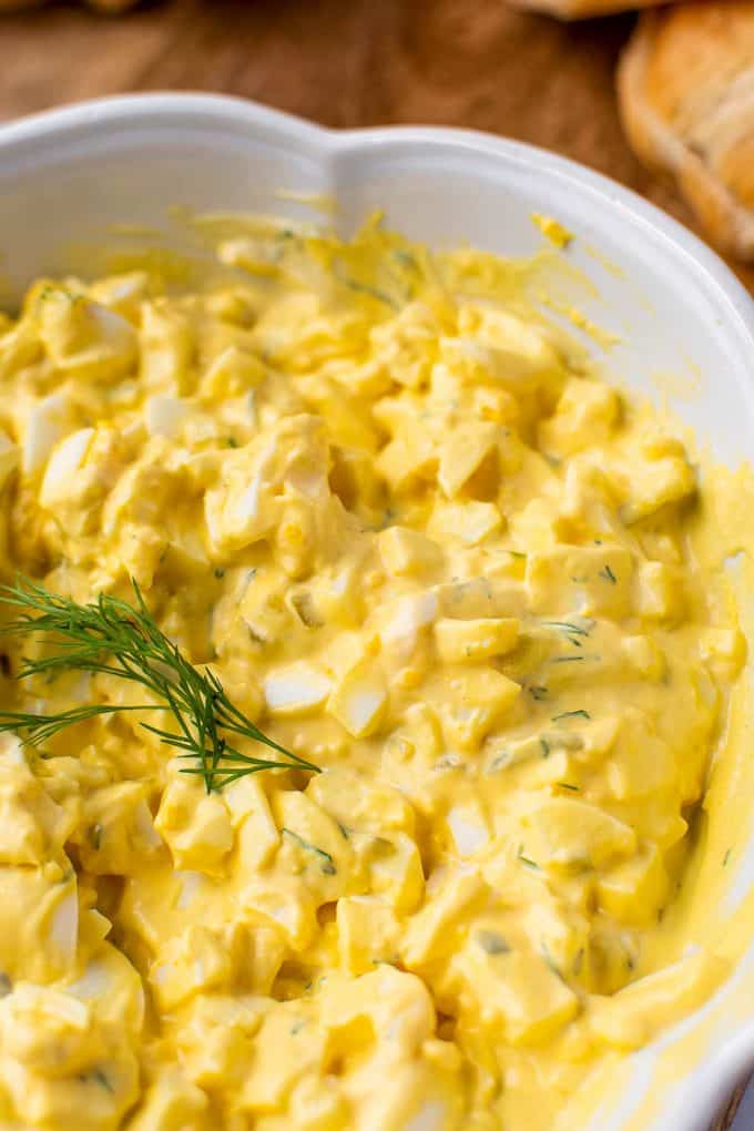 egg salad in a white bowl with dill