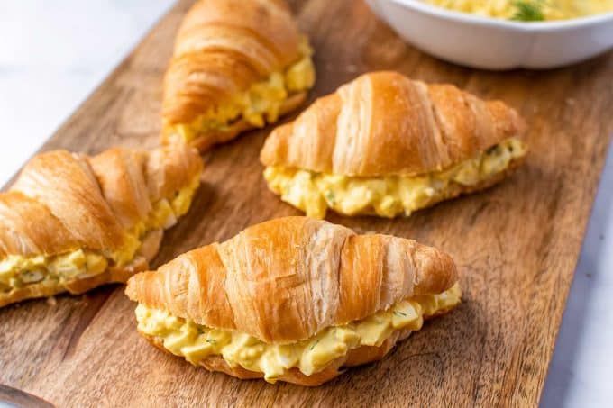 egg salad on croissants on cutting board