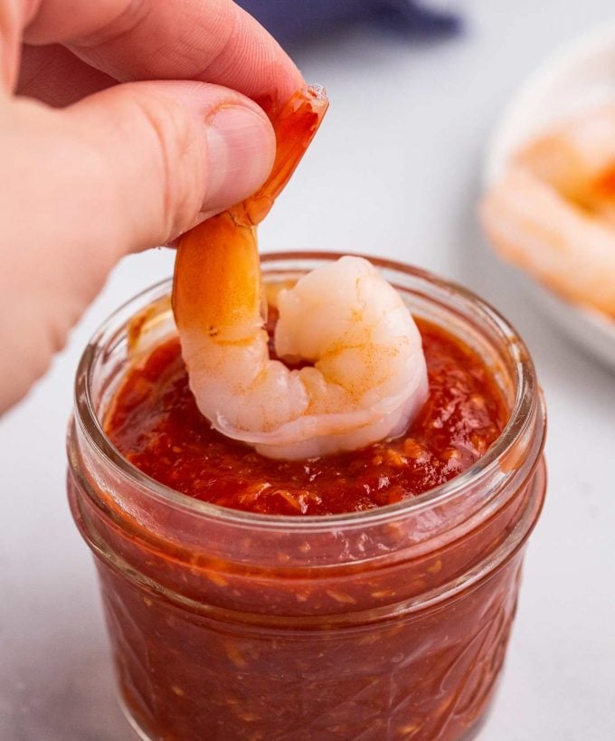 dipping a shrimp into cocktail sauce