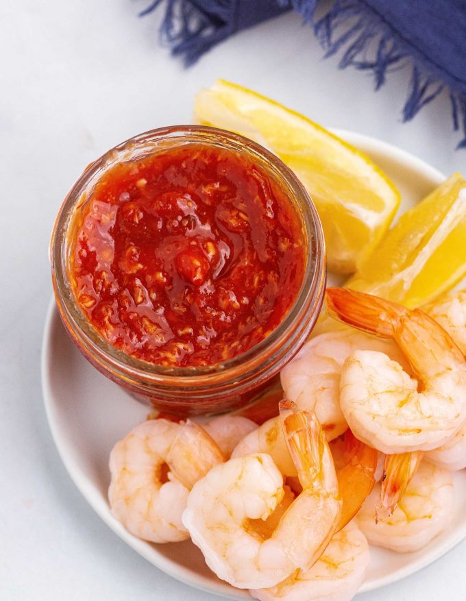 bowl of cocktail sauce with shrimp and lemons
