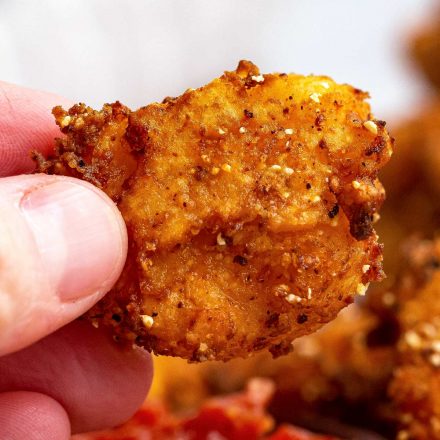 holding a fried shrimp