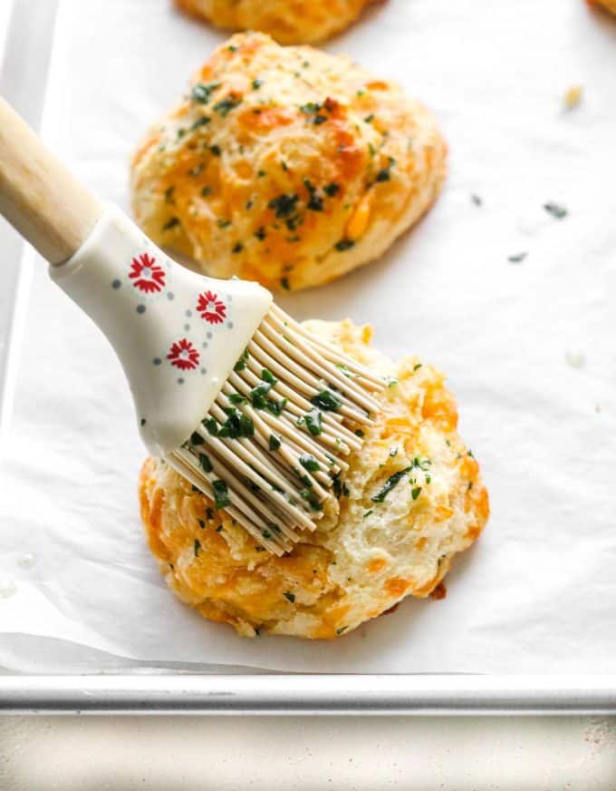 brushing biscuit with garlic butter topping