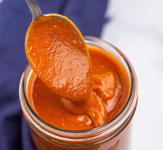 spoonful of enchilada sauce drizzling back into jar