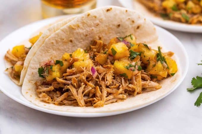 carnitas tacos with pineapple salsa on white plate