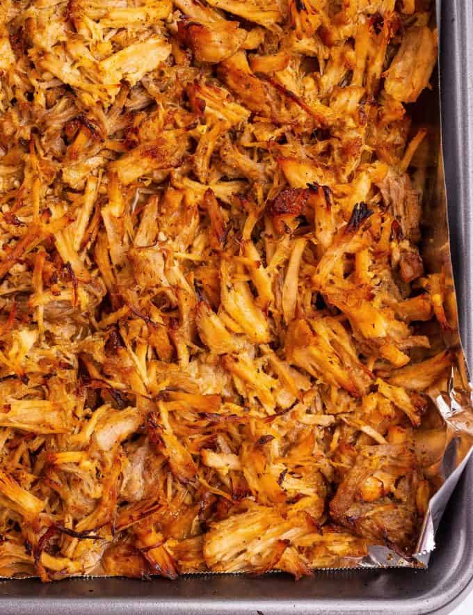 crispy edges of pork carnitas on baking sheet