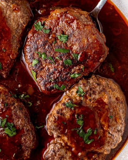 This fun take on classic salisbury steak is an easy comfort food dinner! Homemade ground beef steaks are smothered in the most amazing stout and onion bbq gravy. It's a hearty one pan meal for the whole family. #salisburysteak #beef #groundbeef #dinner #dinnerrecipe #onepan #stout #bbq #guinness