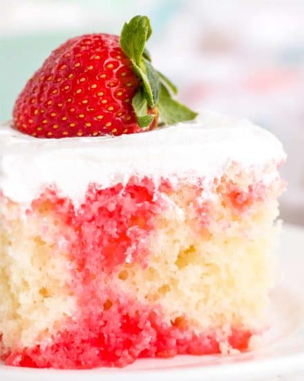 This Strawberry Poke Cake is the easiest and most delicious summer dessert around! Fluffy white cake is infused with strawberry jello, then slathered with whipped cream! Naturally a make ahead dessert, this is a dessert recipe the whole family will love! #pokecake #strawberrydessert #whitecake #dessert #baking #summerdessert