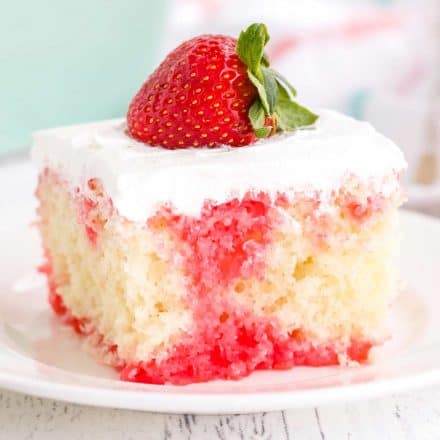 slice of strawberry poke cake on white plate