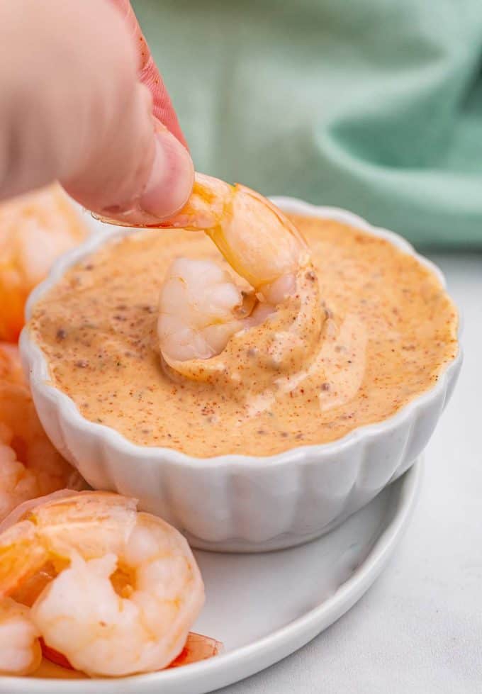 dipping shrimp into cajun sauce