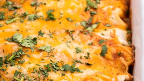These Easy Beef Enchiladas are made with a flavorful ground beef, green chiles, and black bean filling, piled high with cheese, and all smothered in a mouthwatering homemade enchilada sauce and baked to gooey cheesy perfection! #enchiladas #beef #mexican