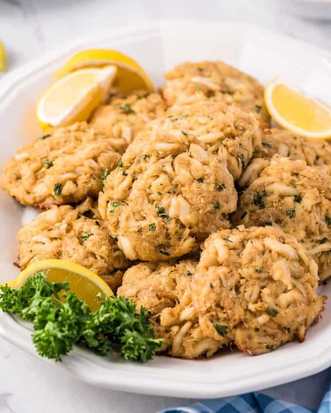 platter of crab cakes with lemon wedges