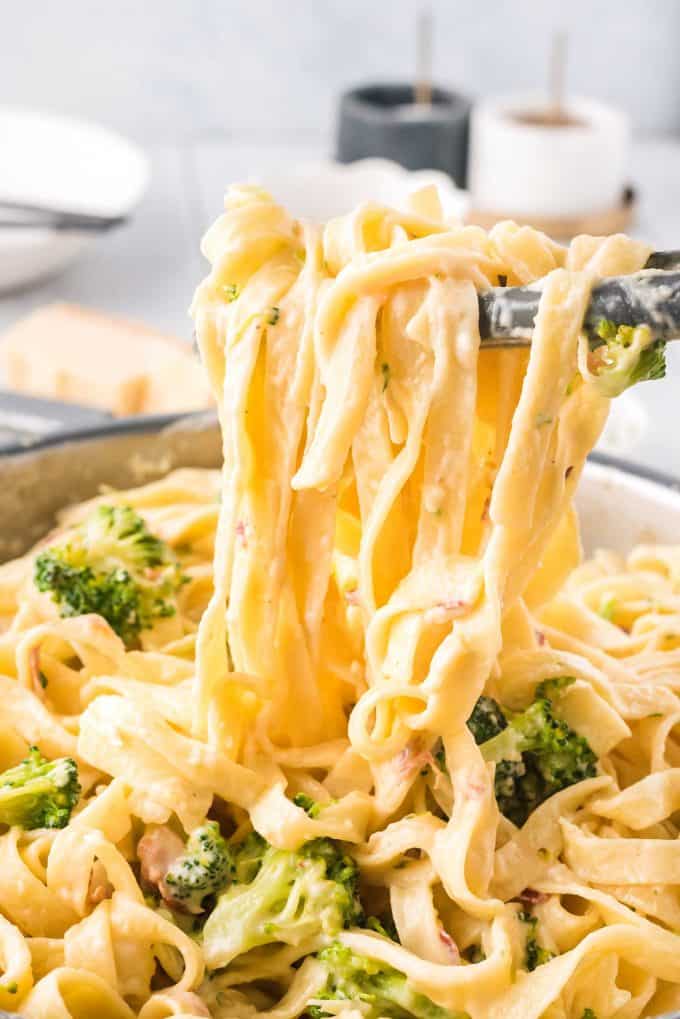 tossing chicken alfredo pasta