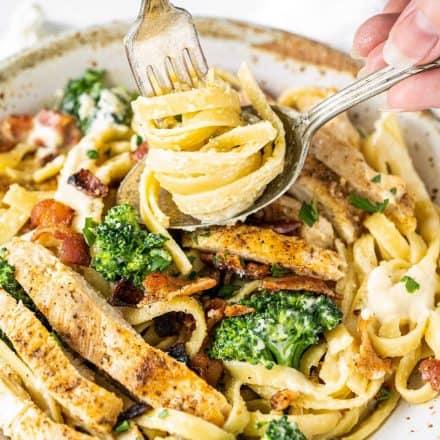 bowl of chicken alfredo with fork twirling pasta