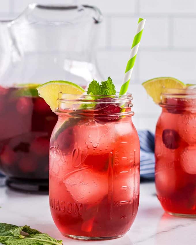 two mason jar glasses of cherry limeade.