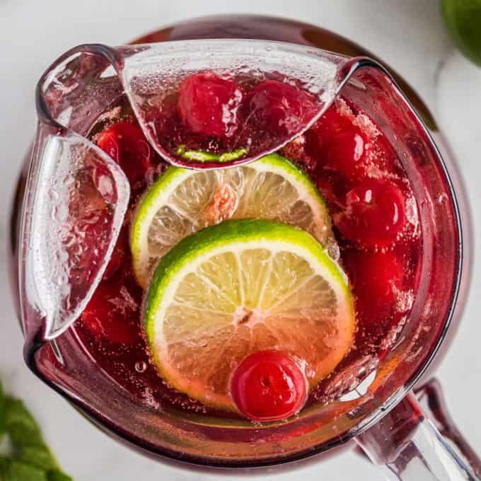 overhead view of cherry limeade in a glass pitcher