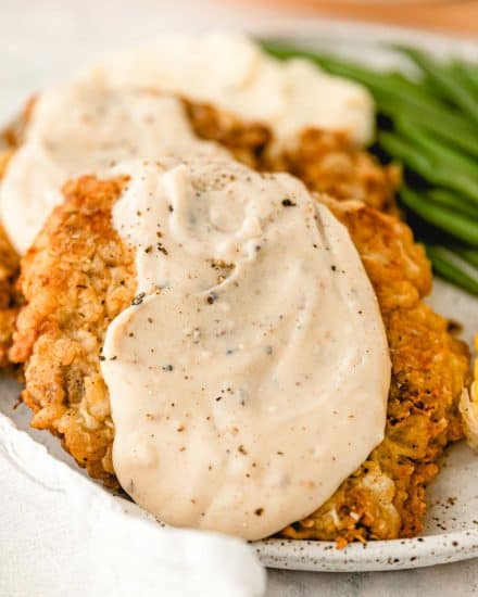 Chicken Fried Steak is a southern classic made with tender marinated cube steaks that have been breaded and pan fried until golden. And don't forget the creamy white pepper gravy on top! Restaurant-quality, but made easily at home. #chickenfriedsteak #beef #dinner #comfortfood