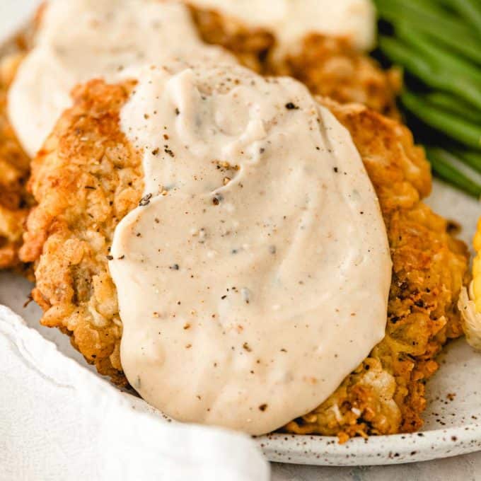 chicken fried steak with white gravy on plate