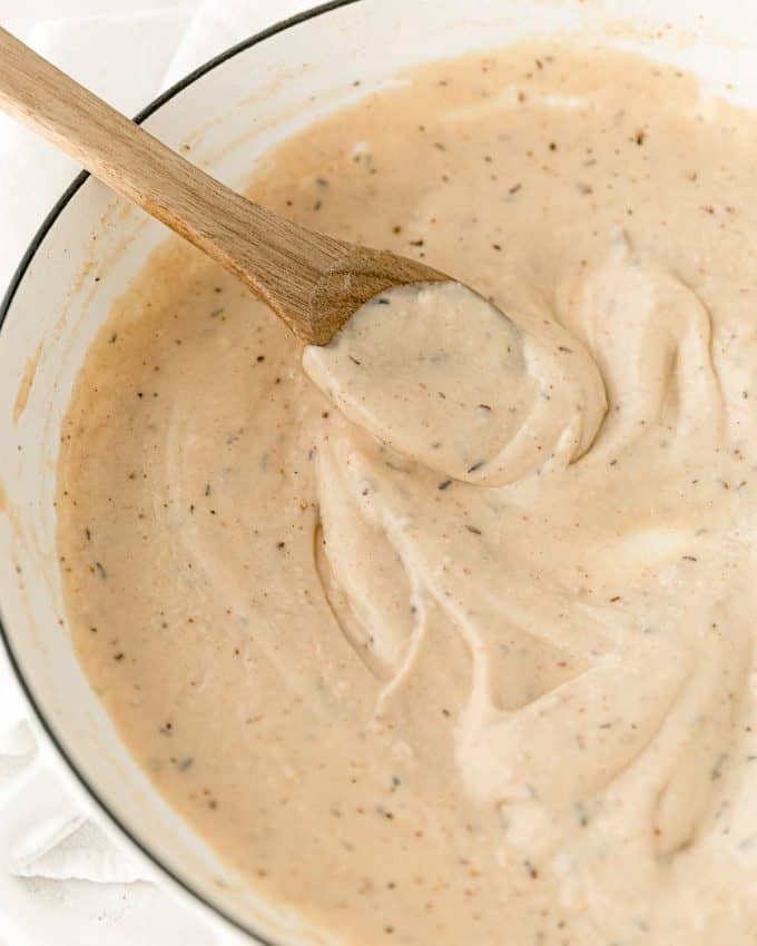 stirring white gravy in pan