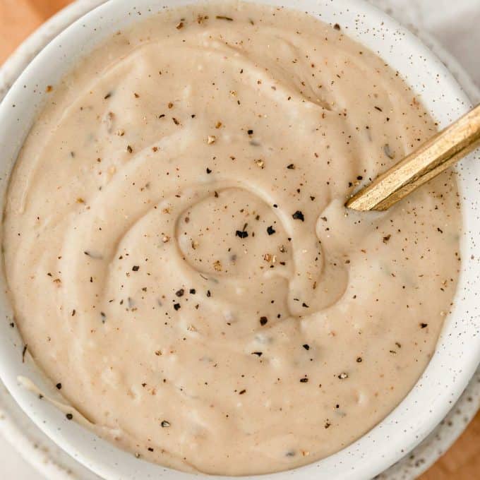 overhead view of white gravy in bowl sprinkled with black pepper