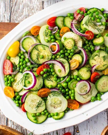 This easy mayo-free Cucumber Salad is complete with not only fresh cucumbers, but also sweet peas, crunchy red onion, tangy tomatoes, fresh herbs and a simple balsamic vinaigrette dressing. Perfect alongside a light summer meal or at a potluck! #cucumber #salad #summer