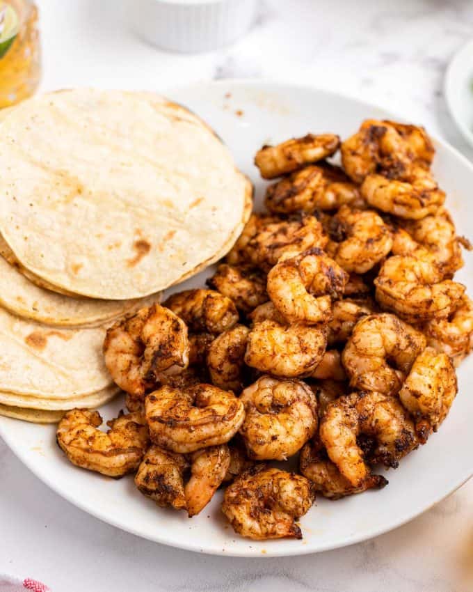 grilled shrimp on plate next to tortillas