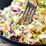 tequila lime coleslaw in black bowl with a fork.