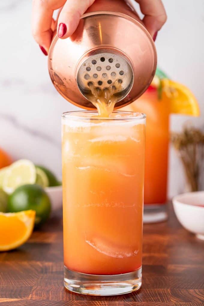 pouring rum punch into cocktail glass