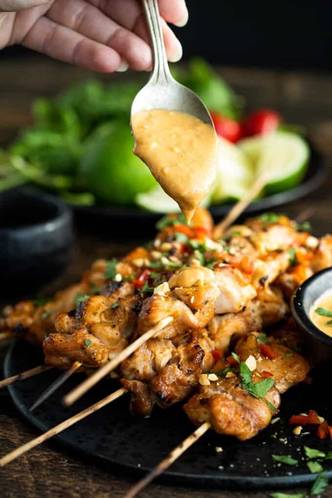 drizzing chicken satay with peanut sauce