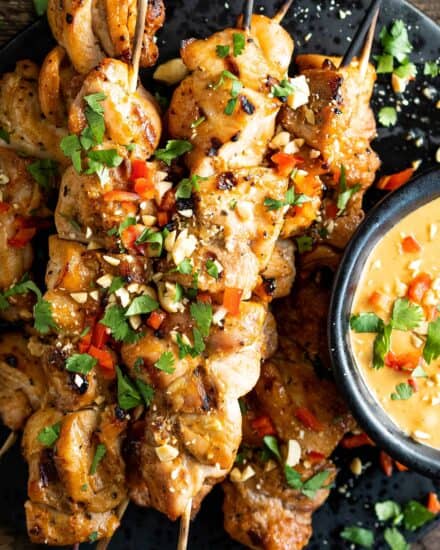 Juicy chicken thighs are marinated in an easy Thai-flavored marinade, then skewered and grilled until a little charred. And of course, don't forget the spicy peanut sauce that you'll be wanting to put on absolutely everything! #chickensatay #thai #peanutsauce #grilled