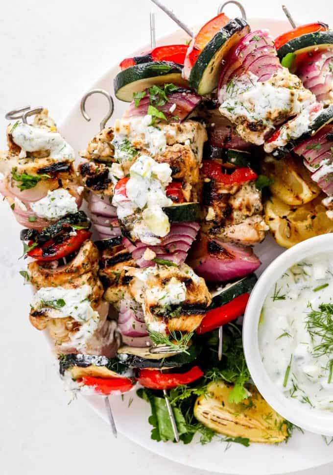 Juicy chicken thighs marinated in an ultra flavorful lemon and herb yogurt sauce, skewered with veggies and grilled to perfection. Perfect for summer, but recipe has alternative cooking methods for winter too! #chicken #greek #kebabs
