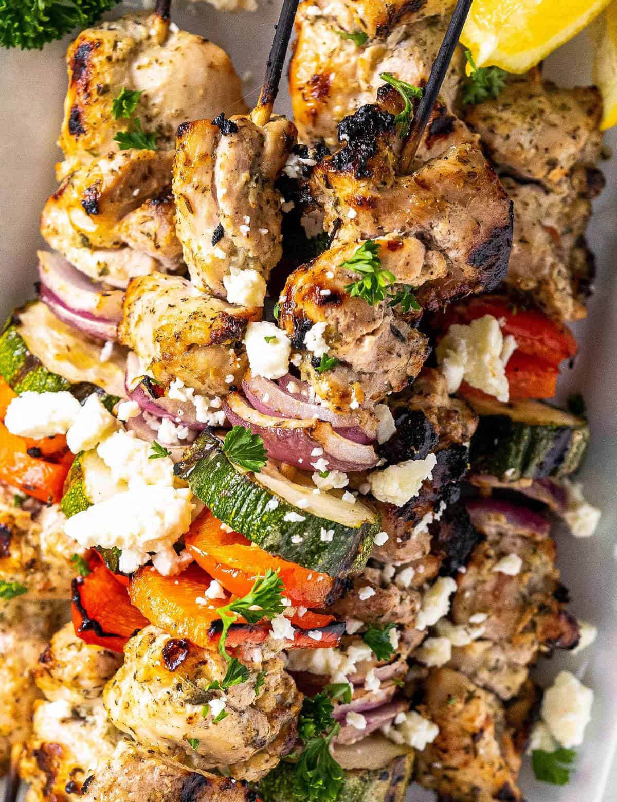 Juicy chicken thighs marinated in an ultra flavorful lemon and herb yogurt sauce, skewered with veggies and grilled to perfection. Perfect for summer, but recipe has alternative cooking methods for winter too! #chicken #greek #kebabs