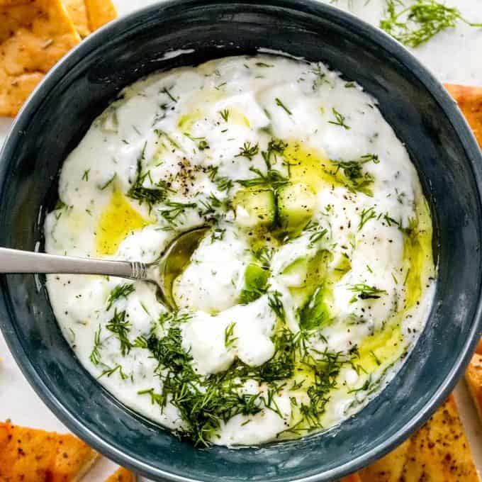 spoon in a bowl of creamy tzatziki sauce