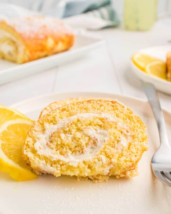 slice of lemon roll cake on plate with fork