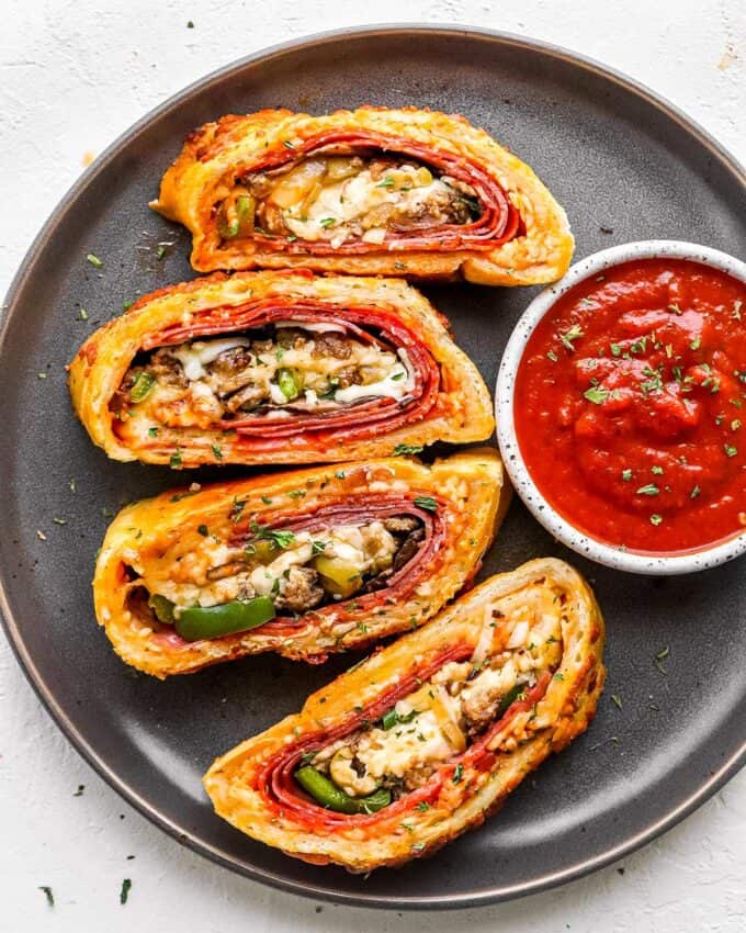 This Stromboli is loaded with Italian meats, cheeses and vegetables, and all wrapped up in a crispy cheesy crust.  Like a deluxe pizza, all rolled up like a burrito.  Great for a busy weeknight when you use store bought pizza dough! #pizza #stromboli #italian