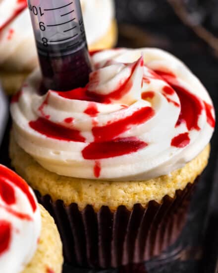 These bloody cupcakes are a delicious way to celebrate Halloween. Moist vanilla cupcakes, smooth vanilla buttercream, and the homemade fake blood really sets the spooky mood! #Halloween #cupcakes #baking