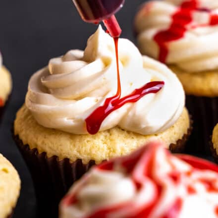 drizzling edible blood over vanilla cupcakes