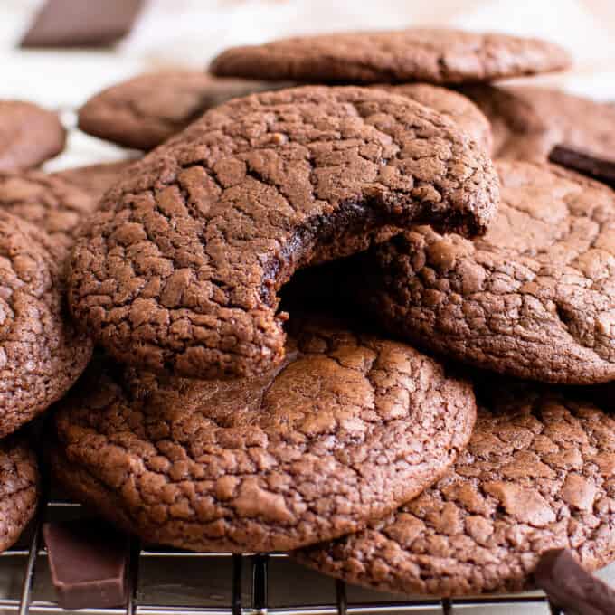 pile of brownie cookies and one with a bite taken out of it