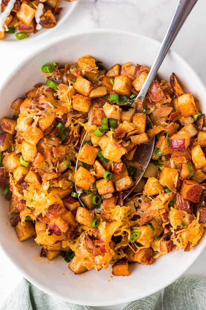 bowl of roasted buffalo potatoes with serving spoon