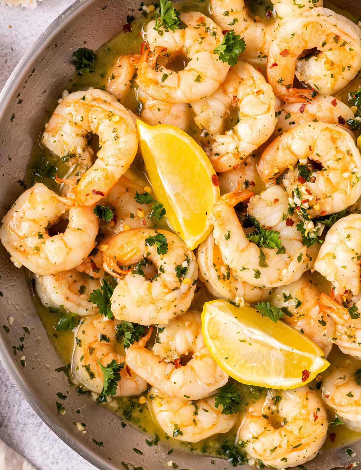 Shrimp Scampi is made with big, juicy shrimp that are cooked in a garlic butter wine sauce! Made in 20 minutes, including prep, it's perfect for a weeknight dinner. Serve with crusty bread, or over some al dente pasta! #shrimp #scampi #seafood #easydinner