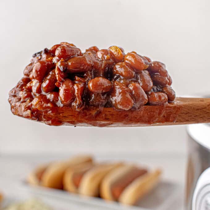 scoop of baked beans on wooden spoon