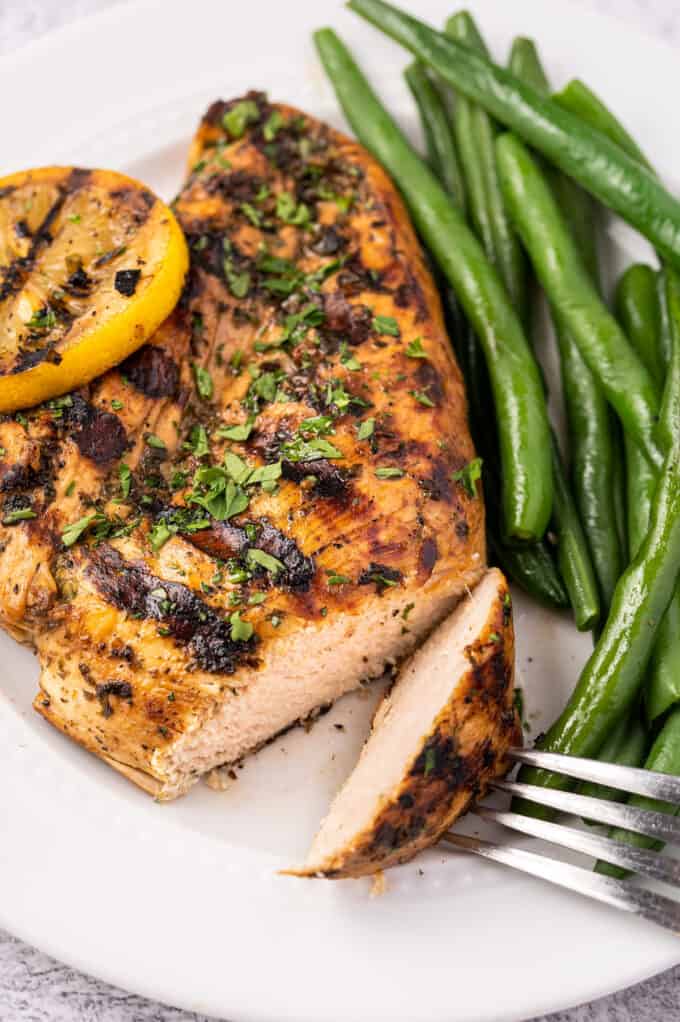 This Lemon Herb Grilled Chicken is juicy and beautifully charred. The easy marinade is perfect for not only chicken, but pork and seafood too. It's a great versatile chicken recipe! #grilled #chicken #lemon