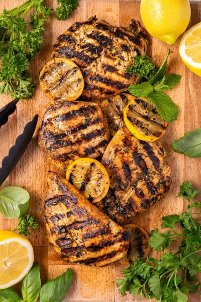 grilled chicken and lemons on a wooden tray