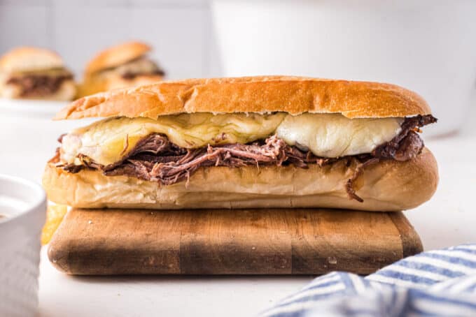 classic french dip sandwich on cutting board