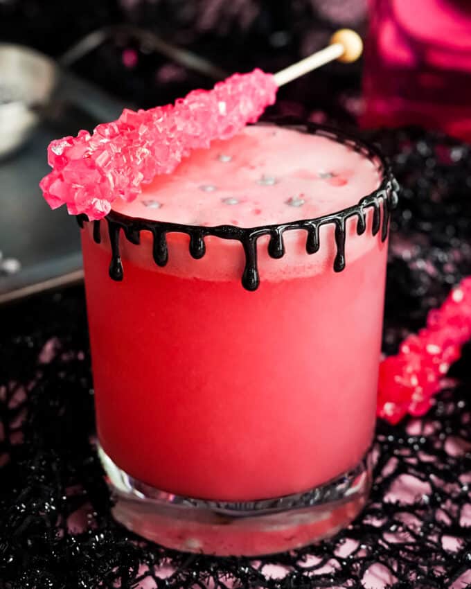 pink witch drink with rock candy as a stirrer