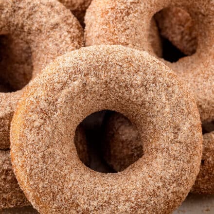 These Baked Apple Cider Donuts are soft and tender, full of warm Fall spices, and covered in a crunchy cinnamon sugar coating! Everything you love about apple cider, in a fun donut! #applecider #donuts #baking