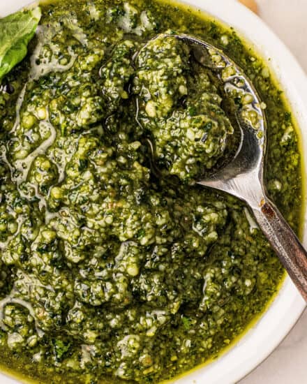 This Classic Basil Pesto recipe is made in just 15 minutes with plenty of fresh basil, parsley, pine nuts, garlic, olive oil and Parmesan cheese. Perfect on pasta, sandwiches, drizzled over veggies or pizza, stirred into Alfredo sauce, used in soups, and more! #pesto #sauce #Italian